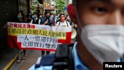 Pro-democracy protesters hold a banner during a demonstration against the election of Hong Kong's next chief executive on May 8, 2022. (Lam Yik/Reuters)