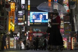 8일 일본 도쿄의 대형 스크린에 스가 요시히데 총리가 급증하는 신종 코로나바이러스 확산으로 비상사태를 선포하는 뉴스가 보도되고 있다.
