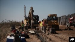 Trabajadores preparan las bases de una sección metálica del muro fronterizo que separa Ciudad Juárez, México, de Sunland Park, Nuevo México, Estados Unidos, el 12 de enero pasado.