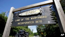 In this Monday, June 25, 2018 photo a wooden sign advises motorists of the location of Mashpee Wampanoag Tribal lands in Massachusetts. The Mashpee Wampanoag Tribe says an unfavorable decision from the U.S. Interior Department on its tribal…