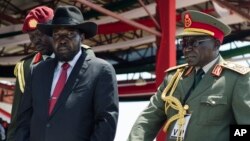 L'ex-chef redouté de l'armée Paul Malong, à droite, accompagne le président Salva Kiir, lors d’un passage des troupes en revue à Juba, Soudan du Sud, 9 juillet 2015.