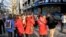 Foreign tourists consult with South Korean tour guides wearing red jackets in a crowded shopping district in Seoul on Apr. 9, 2013.