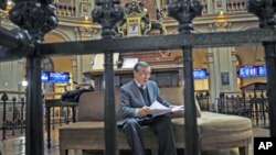 A trader reads at Madrid's bourse as euro gave up gains on comments from a senior German official who dampened optimism that European leaders will take decisive steps to contain the region's debt crisis at this week's summit, in Madrid, Spain, December 7,