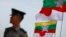 A police officer stands on guard near national flags of Myanmar and Japan during the commencement ceremony of the Thilawa Special Economic Zone (SEZ) project in the Japanese Special Economic Zone at Thilawa outside Yangon November 30, 2013. The first pha
