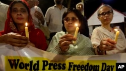 FILE - Pakistani journalists attend a candlelight vigil to observe the World Press Freedom Day, which was declared by the UN General Assembly in 1993, May 3, 2019, in Karachi, Pakistan. 