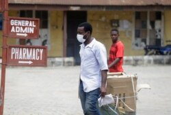 A man wearing face mask walks at the Yaba Mainland hospital where an Italian citizen who entered Nigeria on Tuesday from Milan on a business trip, the first case of the COVID-19 virus is being treated in Lagos Nigeria, Feb. 28, 2020.