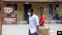 A man wearing face mask walks at the Yaba Mainland hospital where an Italian citizen who entered Nigeria on Tuesday from Milan on a business trip, the first case of the COVID-19 virus is being treated in Lagos Nigeria, Feb. 28, 2020.