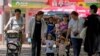People bring their children to a public park on International Children's Day in Beijing, June 1, 2021.
