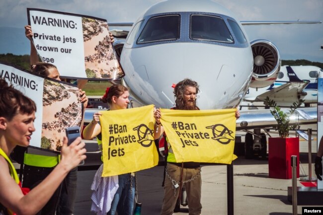 Activists hold banners during a demonstration against Private jets at the European Business Aviation Convention & Exhibition (EBACE) in Geneva, Switzerland, May 23, 2023. Thomas Wolf/Stay Grounded/Handout via REUTERS