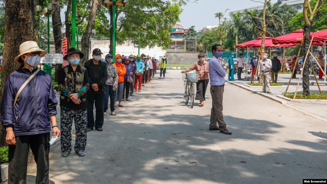 Người dân xếp hàng nhận gạo miễn phí từ máy ATM ở Hà Nội. Photo CAND.