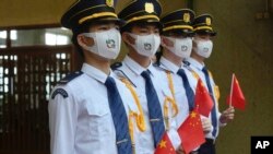 Sejumlah siswa membawa bendera nasional China selama upacara pengibaran bendera untuk menandai peringatan 24 tahun penyerahan Hong Kong ke China di sebuah sekolah di Hong Kong, Kamis, 1 Juli 2021. (Foto: AP/Vincent Yu)