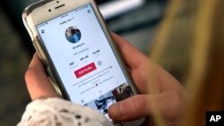 In this Feb. 28, 2018 photo, a person logs into the smartphone app Musical.ly, now known as TikTok, in Wethersfield, Conn. (AP Photo/Jessica Hill, File)