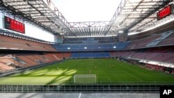 FILE - A view of the empty San Siro stadium during the Serie A soccer match between AC Milan and Genoa, in Milan, Italy, March 8, 2020. 