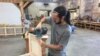 American College of the Building Arts sophomore Steven Fancsali sands a piece of wood for a workbench, in Charleston, S.C., Sept. 17, 2019. (J. Taboh/VOA News)