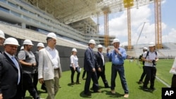 Sekjen FIFA Jerome Valcke (tengah) dan Menteri Olahraga Brazil Aldo Rebelo (mengenakan jaket tipis), menginspeksi stadion Arena de Sao Paulo, Brazil, 20 Januari 2014 (Foto: dok).