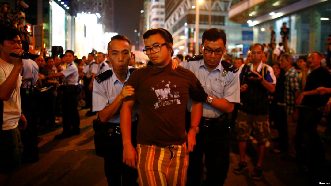 Polisi menangkap seorang pengunjuk rasa prodemokrasi dalam konflik antara pengunjuk rasa anti-Occupy Central dan prodemokrasi di jalan utama di kawasan Mongkok, Hong Kong (3/10). 