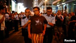 Polisi menangkap seorang pengunjuk rasa prodemokrasi dalam konflik antara pengunjuk rasa anti-Occupy Central dan prodemokrasi di jalan utama di kawasan Mongkok, Hong Kong (3/10). 