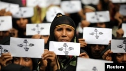 Rohingya refugee women hold placards as they take part in a protest at the Kutupalong refugee camp to mark the one-year anniversary of their exodus from Myanmar, in Cox's Bazar, Bangladesh, Aug. 25, 2018.