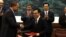 Egyptian President Mohammed Morsi, center left, and Chinese President Hu Jintao, center right, applaud as officials exchange documents during a signing ceremony in Beijing, China, August 28, 2012.
