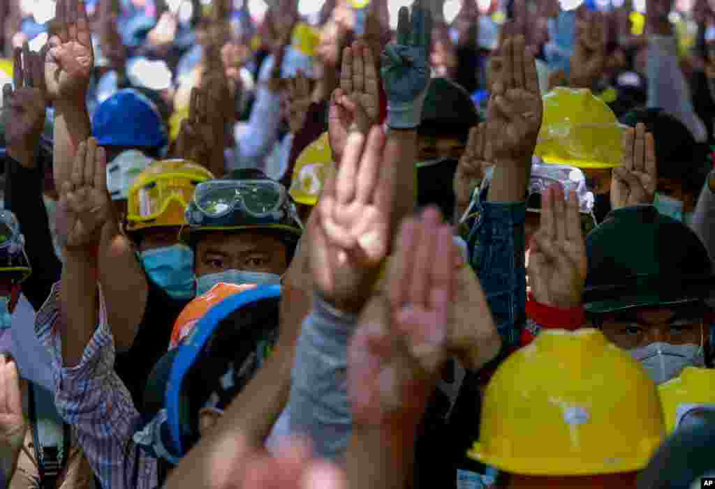미얀마 양곤에서 쿠데타 반대 시위대가 민주화 상징인 세 손가락을 표시하고 있다.