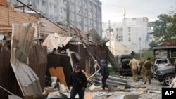乌克兰国家警察提供的照片显示，警察和救援人员走在克拉马托尔斯克被俄罗斯空袭击中的披萨餐厅废墟前。(2023年6月27日)