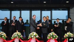 A 2006 photo shows Intel CEO Paul Otellini (C-L) presenting a gift to Li Chuncheng, who was secretary of Chengdu Municipal Committee of the Communist Party, during the completion ceremony of the second project of Intel Products Chengdu Ltd. in Chengdu, Sichuan province.