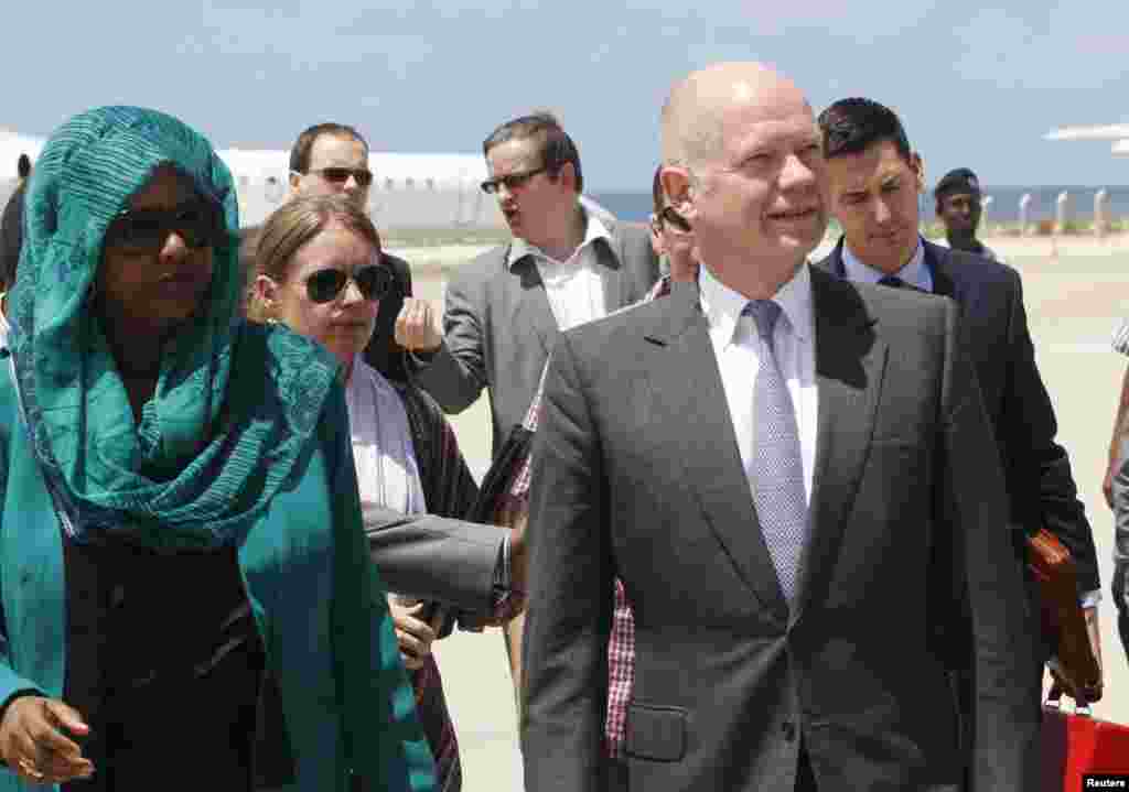 Menteri Luar Negeri Inggris William Hague (kanan) bersama Menteri Luar Negeri Somalia Fauzia Yusuf Haji Adan di bandar udara sebelum pembukaan Kedutaan Besar Inggris di Mogadishu (25/4). Meningkatnya optimisme bahwa Somalia mampu melawan bajak laut dan pemberontak terkait al-Qaida membuat Inggris membuka kedubes di sana. (Reuters/Feisal Omar)