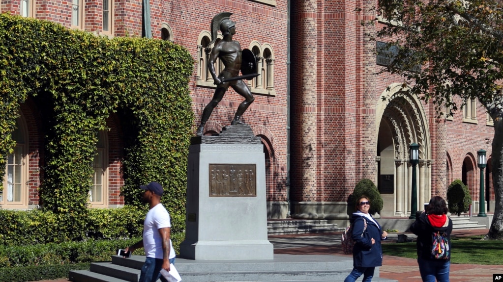 FILE - Students walk in front of the Trojan statue at the University of Southern California. The school will be one of the most costly in the U.S. next year. (AP Photo/Reed Saxon, File)