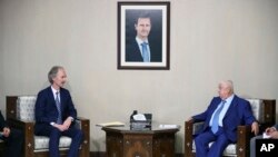 The U.N.'s special envoy for Syria Geir Pedersen, left, meets with Syrian Foreign Minister Walid al-Moallem, in Damascus, Syria, Sept. 23, 2019.