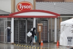 FILE - A Tyson Fresh Meats plant employee leaves the plant, in Logansport, Ind., April 23, 2020.