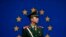 FILE - A Chinese paramilitary policeman stands on duty in front of a European Union flag outside the office of the European Union delegation to China, in Beijing, Oct. 28, 2011.