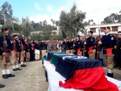 FILE - Pakistani police officers attend the funeral for their colleagues in Lower Dir, Dec. 18, 2019. Gunmen shot and killed the two policemen who were part of an anti-polio drive in the volatile northwest.