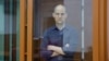 FILE - Wall Street Journal reporter Evan Gershkovich, who stands trial on spying charges, is seen inside an enclosure for defendants before a court hearing in Yekaterinburg, Russia, June 26, 2024. 
