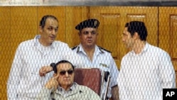 Mantan Presiden Mesir Hosni Mubarak (duduk) bersama dua putranya, Gamal Mubarak (kiri) dan Alaa Mubarak (kanan) menghadiri sidang dengar keterangan di Akademi Kepolisian Mesir di Kairo, 14 September 2013. (Foto: dok). 