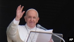 FILE - In this July 4, 2021 photo, Pope Francis waves to the crowd as he arrives to recite the Angelus noon prayer from the window of his studio overlooking St.Peter's Square, at the Vatican.