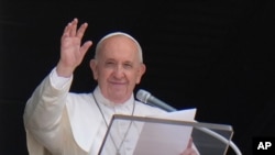 FILE - Pope Francis waves to the crowd as he arrives to recite the Angelus noon prayer from the window of his studio overlooking St.Peter's Square, at the Vatican.