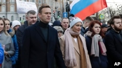 In this photo taken on Saturday, March 29, 2020, Russian opposition activist Alexei Navalny, center left, and his wife Yulia, take part in a march in memory of opposition leader Boris Nemtsov in Moscow, Russia. Russian opposition leader Alexei…