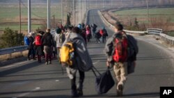 Refugees and migrants make their way to reach the borderline to Macedonia, near the northern Greek village of Idomeni, on Tuesday, Feb. 23, 2016.