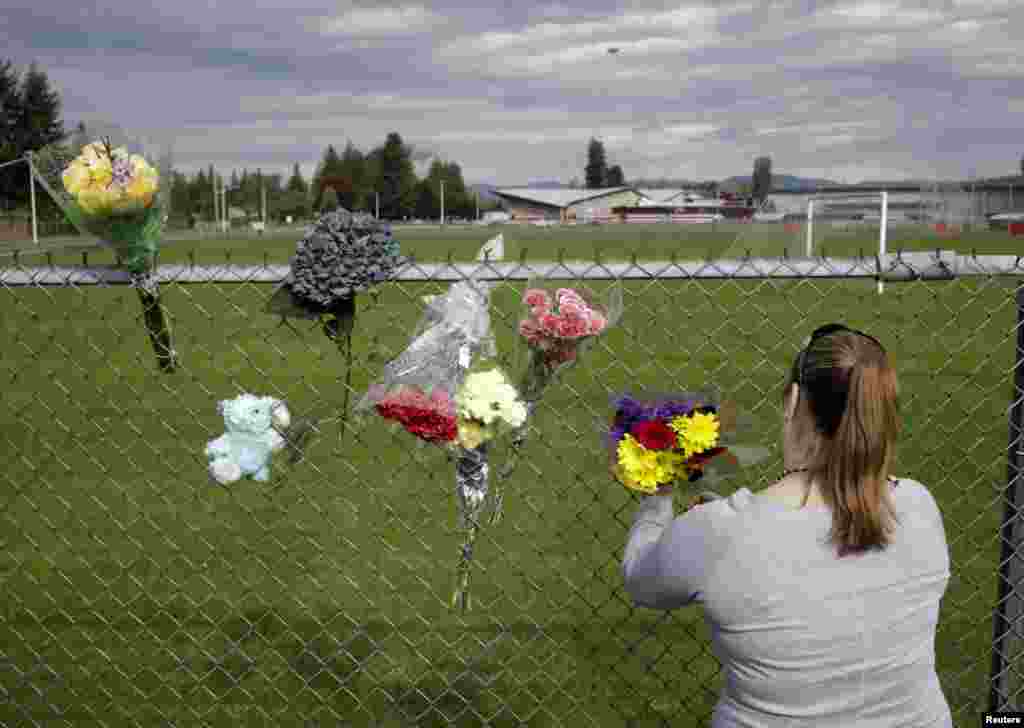 Visitors leave flowers the day after a shooting at Marysville-Pilchuck High School in Marysville, Washington, Oct. 25, 2014.