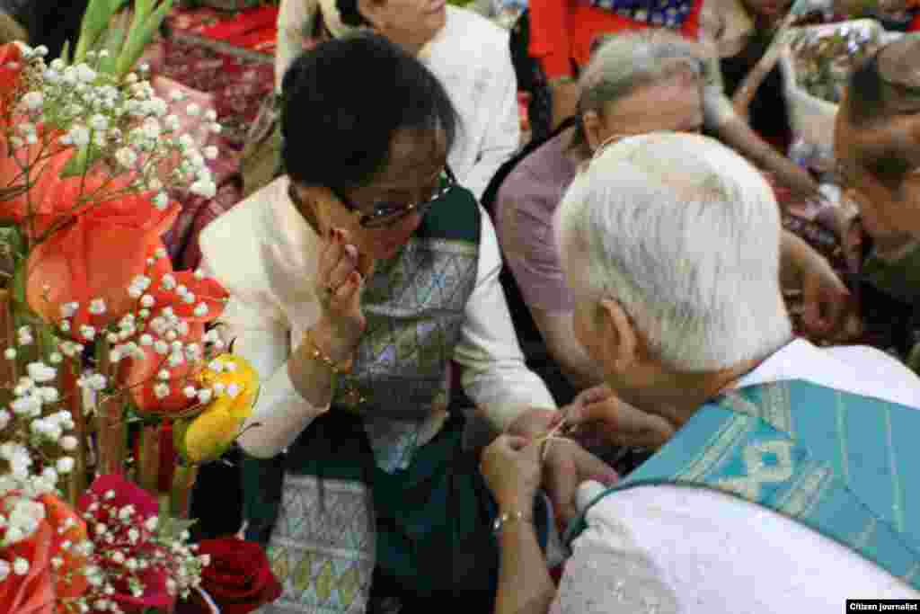 ໝໍພອນ ກໍາລັງມັດແຂນໃຫ້ ທ່ານນາງ ອຸ່ນເຮືອນ ປະຖັມມະວົງ ຕາໂນວັນ