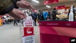 A man sanitizes his hands at the entrance to the media cafeteria, Feb. 7, 2018 in Gangneung, South Korea. There are concerns over the possible spreading of the norovirus, a contagious virus that causes stomach pain, nausea and diarrhea.