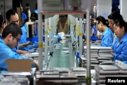 FILE - Employees work on a production line making lithium battery products at a factory in Yichang, China, May 28, 2019. The Trump administration will place a 10% tariff on all Chinese imports Feb. 1, 2025. (Reuters/Stringer)