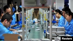 FILE - Employees work on a production line manufacturing lithium battery products at a factory in Yichang, Hubei province, China, May 28, 2019. (Reuters/Stringer)