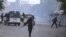 Riot police walk along a road during a protest in Kasserine, Tunisia, Jan. 20, 2016.