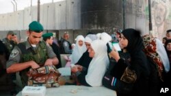 Israeli police check Palestinians waiting to cross an Israeli checkpoint between the West Bank city of Ramallah and Jerusalem. July 26, 2013. 