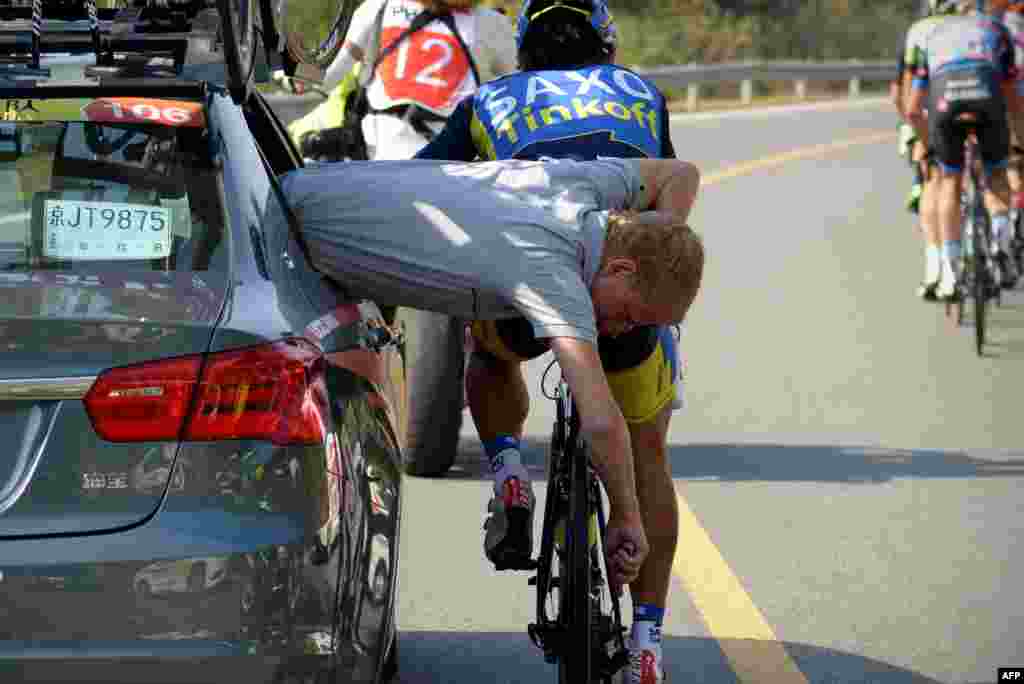 Seorang staf tim Saxo Tinkoff memperbaiki sebuah sepeda peserta perlombaan Tour of  Beijing 2013 di China. 