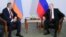 Armenian Prime Minister Nikol Pashinian (L) listens to Russian President Vladimir Putin during their meeting in the Black Sea resort of Sochi, Russia, May 14, 2018.