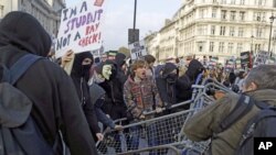 FILE: Students dismantle security barriers placed by British police on Parliament Square during a protest against university tuition fees in London, Nov. 19, 2014.