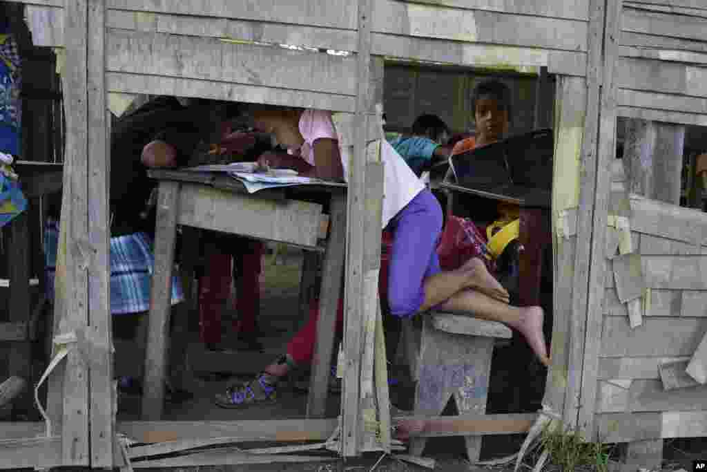 Children study at a run down school in the Amazonian shantytown of Victoria Gracia, Peru, May 8, 2018.