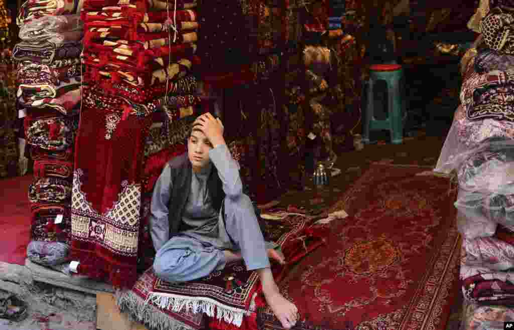 عکسی از کابل. پسر افغان در یک مغازه فرش فروشی در بازار پایتخت افغانستان.